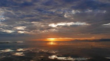 Renkli, bulutlu gün doğumu video Dumaguete şehir shores, ayna gibi gökyüzünü yansıtan okyanus ile gelen.