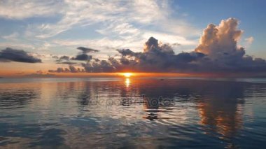 Bir çok renkli gündoğumu video Dumaguete şehir shores okyanus gibi ayna ile üzerinden. Güneş ufuk üzerinde görülebilir. Bir yavaş hareket sembolleri kamera ile çekim.