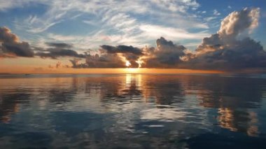 Renkli gün doğumu video Dumaguete şehir shores okyanus gibi ayna ile üzerinden. Güneş bulutların ufku üzerinde sadece gerisindedir. Bir yavaş hareket sembolleri kamera ile çekim.