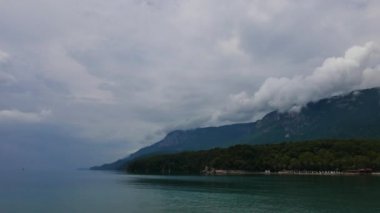 Akyaka kıyısındaki (Gökova Körfezi, Mugla, Turkey) şiddetli yağmur sonra karanlık, bulutlu bir atış. Alçak irtifa cumulus bulutları Sakar dağ dorukları görülebilir. Fırtınadan sonra deniz çarşaf gibi.