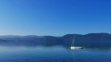 Akyaka kıyı şeridi (Gökova Körfezi, Muğla, Türkiye) plaja, pastoral bir bakış bir sessiz bahar sabahı. Küçük bir yelkende kıyıya yakın bağlantılı görülebilir.