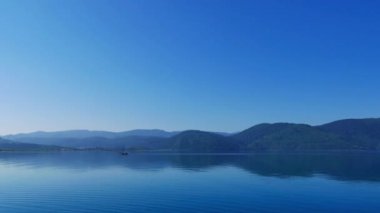Akyaka kıyı şeridi (Gökova Körfezi, Ege Denizi) plaja, geniş açı bakış bir sessiz bahar sabahı. Yerel balıkçı teknesi-ebilmek var olmak seen uzakta, nets toplama sonra geri eve geliyor.