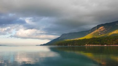 Akyaka kıyı (Gökova Körfezi, Ege Denizi) görünümü üzerinde çok sakin bir sonbahar günü bulutlu. Deniz kıyı şeridi ve gökyüzü bir ayna gibi yansıtır.