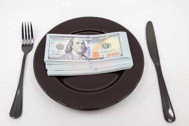 Çatal ve bıçakla dolu yüzlerce dolarlık banknotlar. Refah ve bolluk kavramı. Tam tabak konsepti. Boşluğu kopyala
