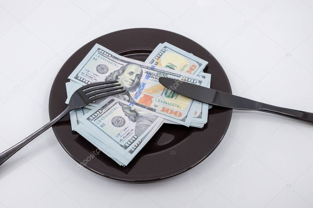 Plate full hundreds of dollar bills with fork and knife. Concept of prosperity and abundance. Full plate concept. Concept of dine out cost Copy space