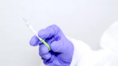 Mavi ameliyat eldivenli bir mikrobiyolog ya da tıp çalışanı aşıyı hızla yayılan Coronavirus için bir şırıngayla birine veriyor. COVID-19 aşı konsepti