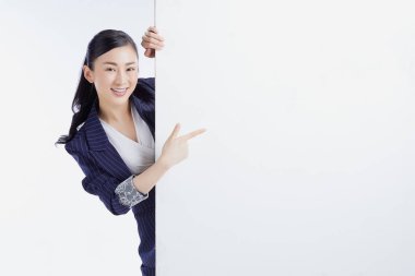 İş kadını beyaz arka planda boş bir ilan panosu sunuyor. Reklam kavramı