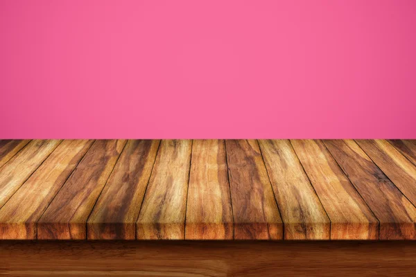 Pusty góry drewniany stół na różowym tle. — Zdjęcie stockowe