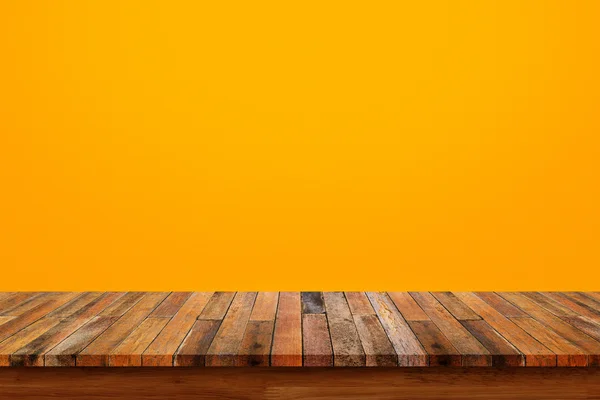 Tampo da mesa de madeira na parede laranja — Fotografia de Stock