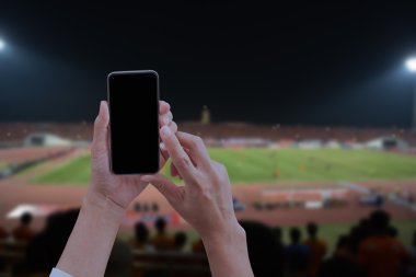 Mobil akıllı telefon ile siyah perde, bulanık socce tutan el