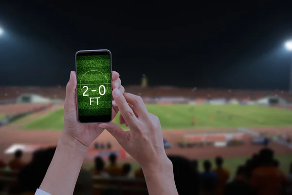 Futbol sahası, bulanık soc ile mobil akıllı telefon tutan el
