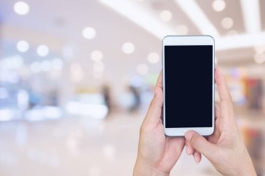 Kadının ve akıllı telefon ile tutarak süpermarket arka plan bulanıklık