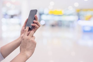 Kadının ve akıllı telefon ile tutarak süpermarket arka plan bulanıklık