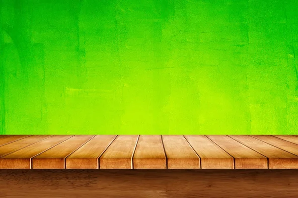 Boş üst kısmındaki yeşil zemin üzerine ahşap masa. 