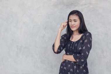 Asyalı kadın beton duvar arka plan üzerinde düşünme.