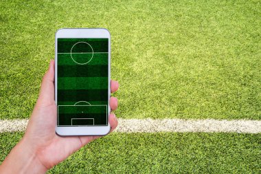 Futbol Stadyumu ekranlı mobil akıllı telefon tutan el.