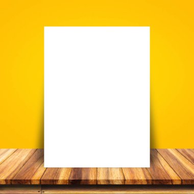 Beyaz kağıt poster sarı duvar ve ahşap masa yalın.