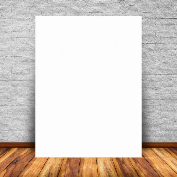 Blank white paper poster lean at brick wall and wood floor. For text input or according to your design.