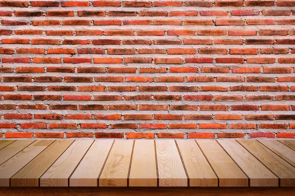 Empty wooden table with red brick wall background.