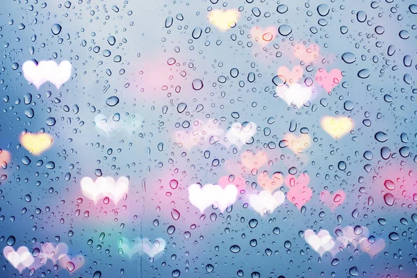 Краплі дощу на склі з абстрактними серцевими ліхтарями — стокове фото