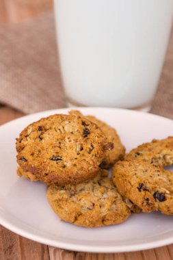 Cam ahşap masa üzerinde sütlü çikolatalı kurabiye.