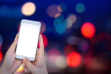 El soyut ile akıllı telefon tutarak bokeh siyah bac üzerinde ışıklar.