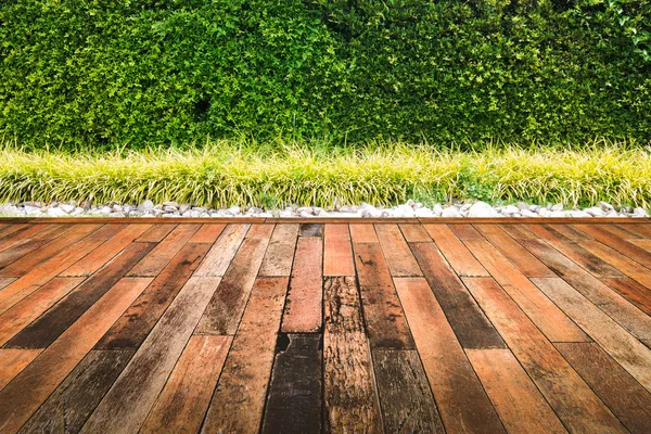 Bahçedeki eski ahşap zemin ile yeşil yaprakları duvar.