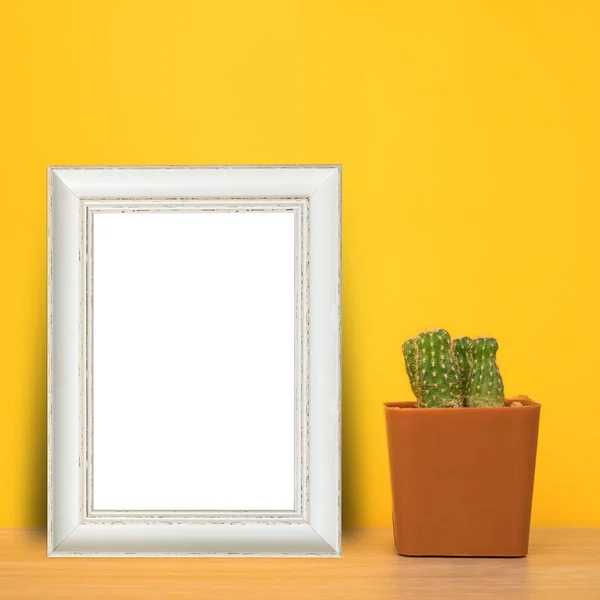 White wood frame with cactus in pot on table