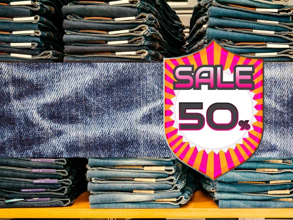 50% de descuento en vaqueros azules en el fondo de la tienda . — Foto de Stock