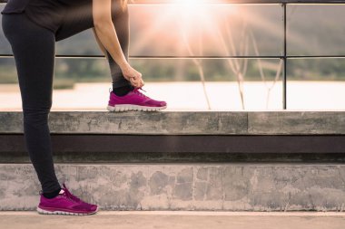 Bağcıklarını bağlayan genç bir kadın koşucu