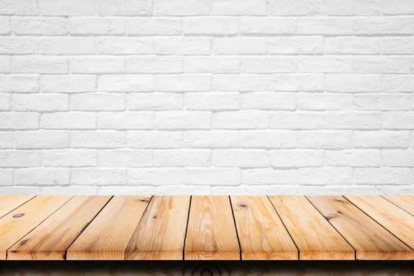 Empty top of wooden table on white brick background.