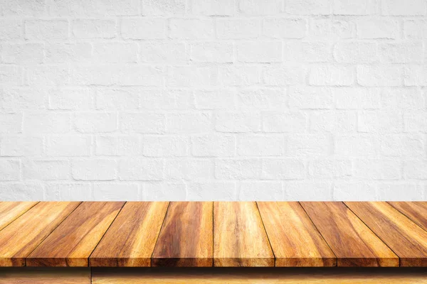 Empty top of wooden table on white brick wall background.