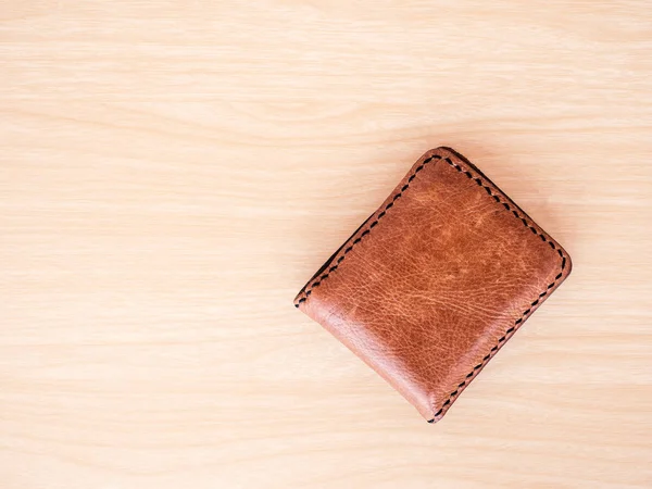 Billetera marrón sobre fondo de mesa de madera . — Foto de Stock