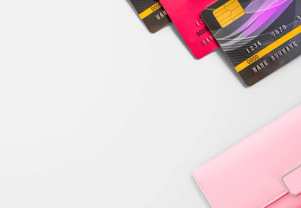 Tarjeta de crédito y billetera rosa sobre fondo blanco . — Foto de Stock