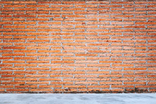 Outdoor concrete floor texture with red bricks wall background. — Stock Photo, Image