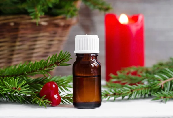 Kleine Flasche ätherisches Öl und Tannenzweige. Weihnachten oder Valentinstagsgeschenk. Aromatherapie und Wellness-Konzept. — Stockfoto