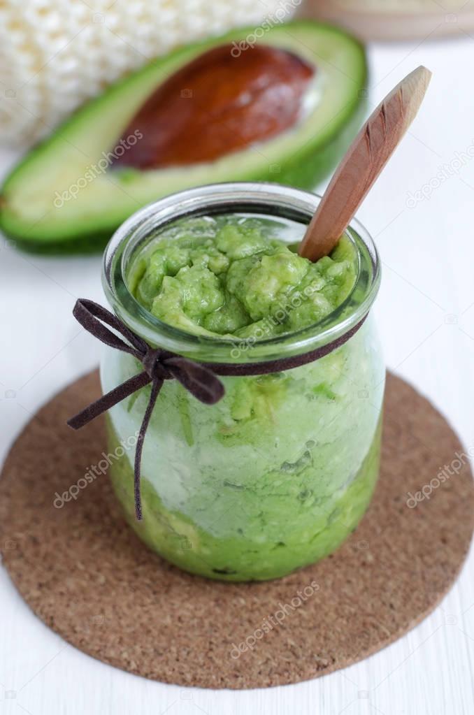 Homemade avocado mask in a glass jar. Prepared from mashed avocado and olive oil. Diy cosmetics. 