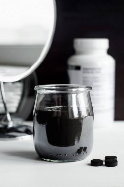 DIY kömür yüz maskesi küçük bir seramik kase. Ev yapımı kozmetik.