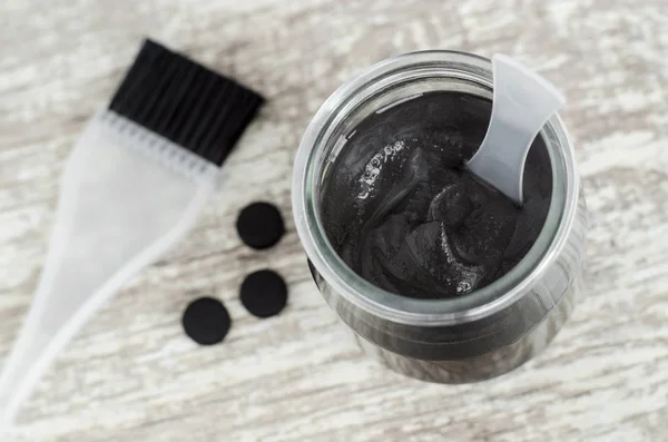 DIY charcoal face mask in a small ceramic bowl. Homemade cosmetics. — Stock Photo, Image