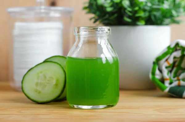 Jugo de pepino en un pequeño frasco de vidrio para preparar tóner facial natural. Cosméticos caseros . — Foto de Stock