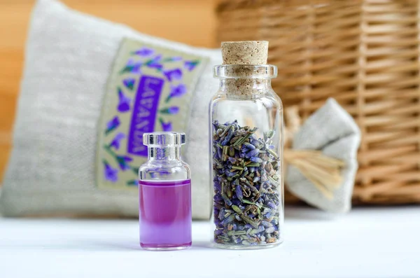 Two small bottles with dry lavender buds and essential aroma oil (perfume, tincture, extract, infusion). Aromatherapy ingredients. — Stock Photo, Image