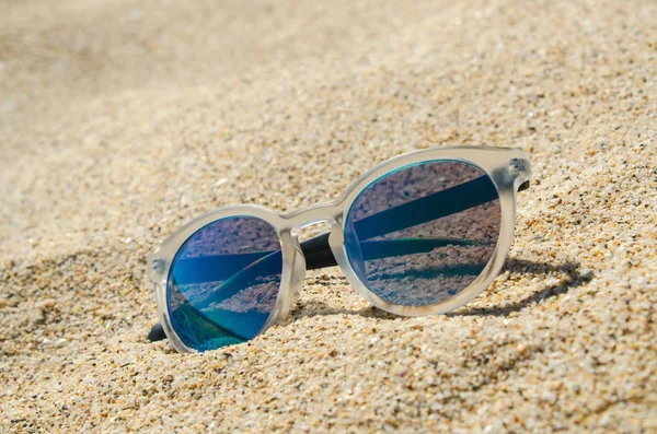 Óculos de sol na praia. Modelo elegante multi colorido com moldura transparente e lentes azuis. Conceito de férias . — Fotografia de Stock