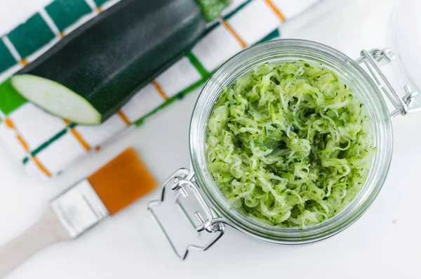 Grated zucchini in a glass jar masker diy wajah alami. Kosmetik buatan sendiri dan spa . — Stok Foto