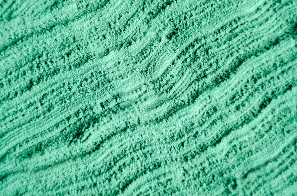 Green cosmetic clay powder texture close up, selective focus. Abstract background