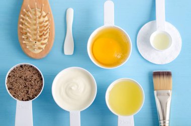 Ekşi krema (Yunan yoğurt), çiğ yumurta, kahve kahverengi şeker ve zeytinyağı içinde küçük bir kaşık toz toprak. DIY maske, önlük, nemlendiriciler hazırlanması için malzemeler. Ev yapımı kozmetik. Üstten Görünüm, kopya alanı.