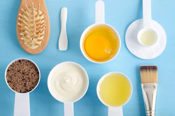 Krim asam (greek yogurt), telur mentah, kopi tanah dengan gula merah dan minyak zaitun dalam sendok kecil. Bahan-bahan untuk menyiapkan masker, semak-semak, pelembab. Kosmetik buatan sendiri. Tampilan atas, ruang penyalinan . — Stok Foto