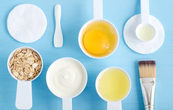 Sour cream (or greek yogurt), raw egg, rolled oats, olive oil in a small scoops. Ingredients for preparing diy masks, scrubs, moisturizers. Homemade cosmetics. Top view, copy space. — Stock Photo, Image