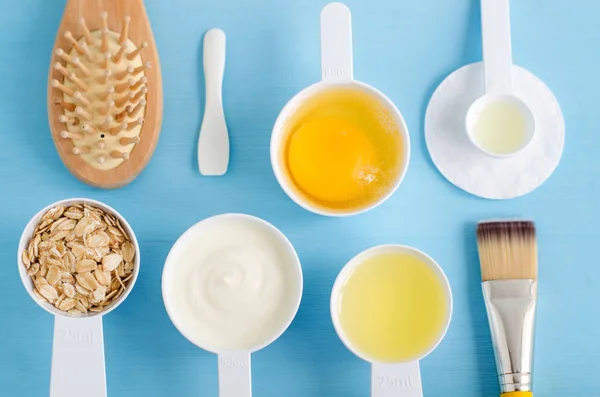 Krim asam (atau yogurt hijau), telur mentah, oat gulung, minyak zaitun dalam satu sendok kecil. Bahan-bahan untuk menyiapkan masker, semak-semak, pelembab. Kosmetik buatan sendiri. Tampilan atas, ruang penyalinan . — Stok Foto