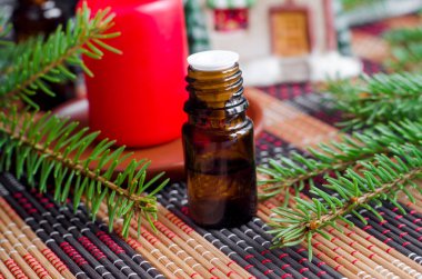 İçinde köknar yağı ve köknar ağacı dalları olan küçük bir şişe. Noel aromalı terapisi. Kış kaplıcası ve bitkisel ilaç malzemeleri. Boşluğu kopyala   