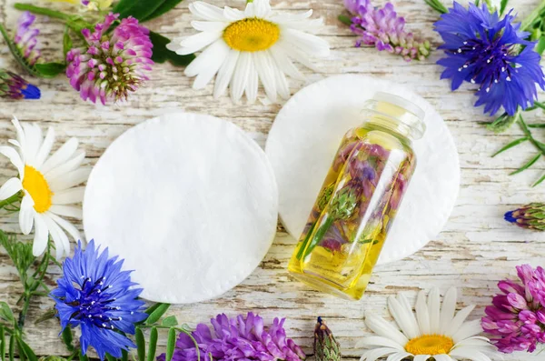 Liten flaska med vilda blommor infusion (extrakt, tinktur, eterisk olja). Aromaterapi, spa och örtmedicin koncept. Ovanifrån, kopiera utrymme. — Stockfoto